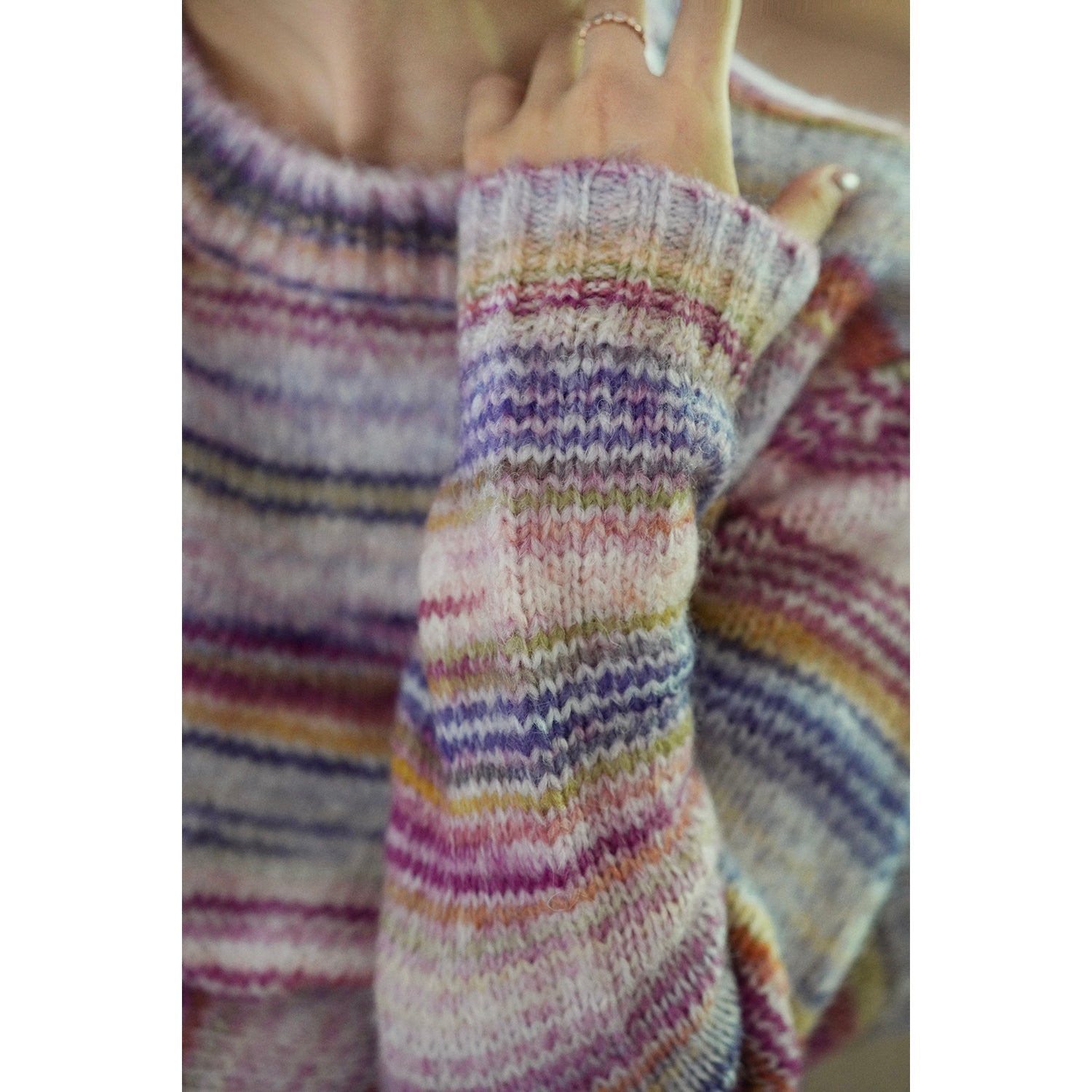 Blurred rainbow-colored knit sweater and scarf