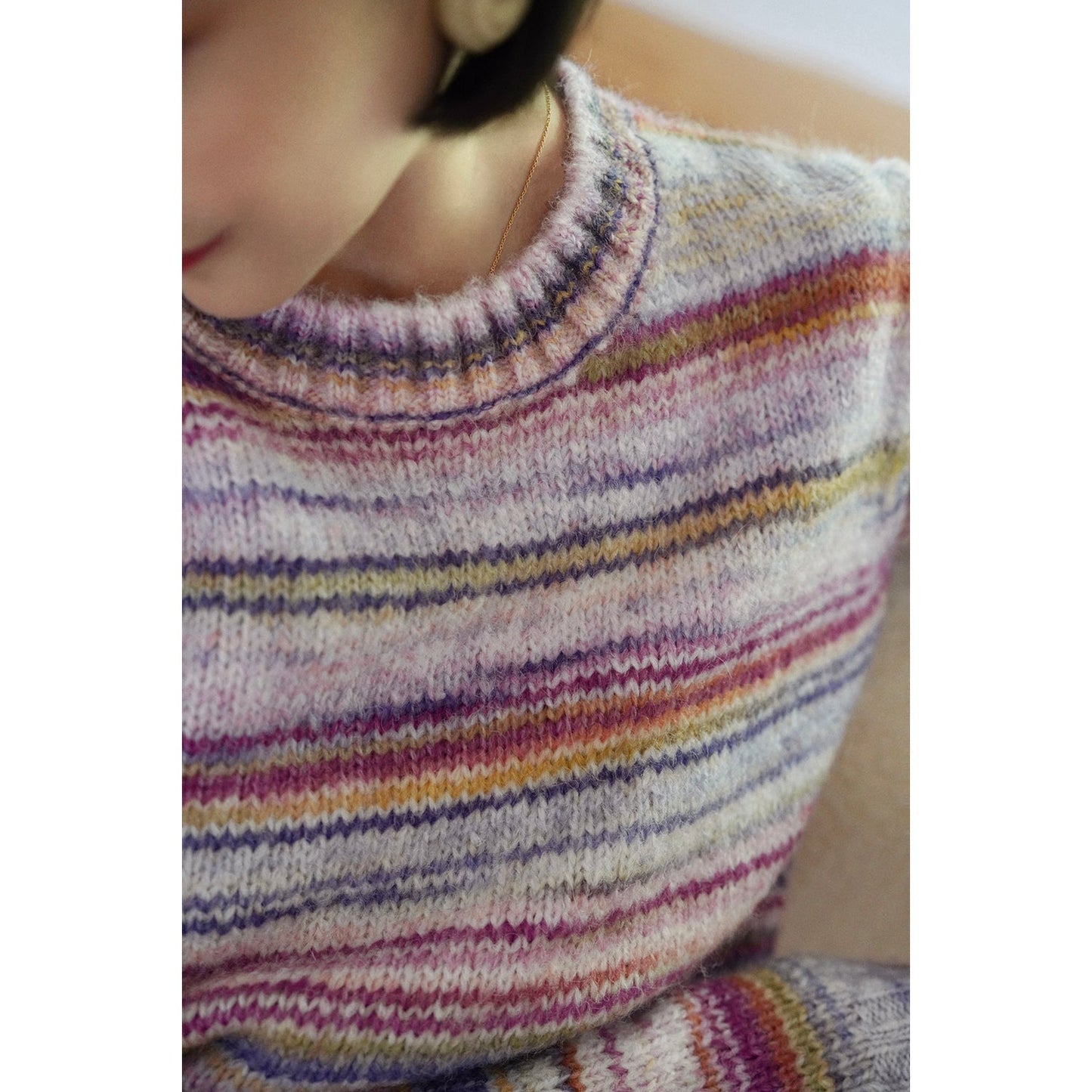 Blurred rainbow-colored knit sweater and scarf